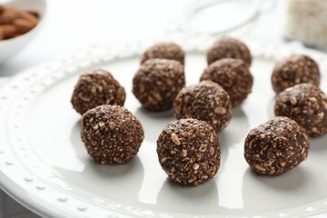 Tasty chocolate candies with nuts on white table, closeup