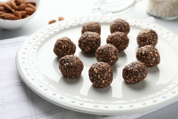 Tasty chocolate candies with nuts on white table, closeup