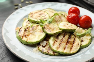 Delicious grilled courgette slices with tomatoes and microgreens on table, closeup