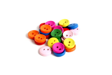 There are many multi-colored buttons on a white background.	