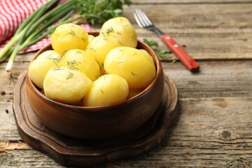 Tasty young boiled potatoes with dill served on wooden table, closeup