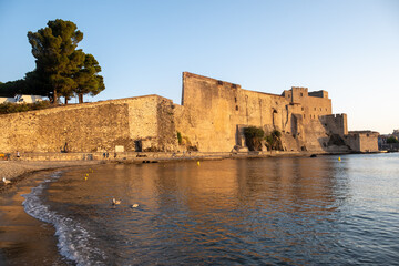 Morning view of colourful Collioure, narrow streets and yellow, pink, orange houses, summer vacation destination town with historical buidings and beaches, Pyrenees-Orientales, France