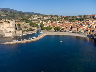 Fototapeta premium Aerial view of colourful Collioure, narrow streets and yellow, pink, orange houses, summer vacation destination town with historical buidings, beaches, Pyrenees-Orientales, France
