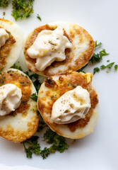 French high cuisine starter dish, pan fried chicken eggs with special filling and yellow sauce, vegetarian food in French restaurant