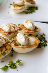 French high cuisine starter dish, pan fried chicken eggs with special filling and yellow sauce, vegetarian food in French restaurant