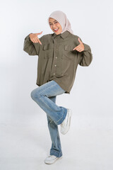 A cheerful woman displays her stylish outfit in a playful pose, radiating joy and energy