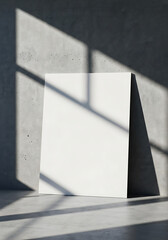 Freestanding blank white card mockup with crisp edges illuminated by dramatic diagonal shadows.