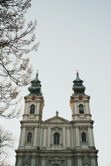 Obraz premium Baroque Catholic church facade in Subotica, Serbia, with twin towers and statues under a clear winter sky
