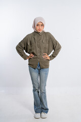 A stylish young woman stands confidently in casual clothes, radiating self-assurance.