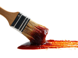Close-up of a paintbrush dripping with a dark red sauce, tracing a line across a dark surface