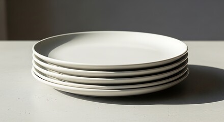 Minimalist composition featuring a stack of clean, modern white plates