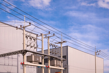 Two factory industrial production buildings with overhead cable tray and electric pole with power...