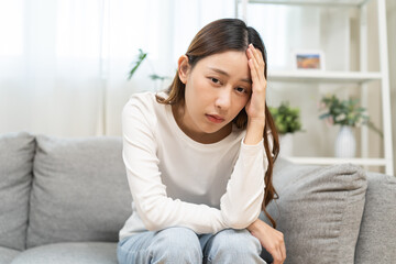 Dizzy asian young woman, girl headache or migraine pain suffering from vertigo while sitting on...