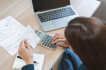 Stressed asian young business woman, employee using calculator to calculate expenses of monthly,...