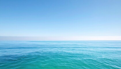 Obraz premium Wide shot of a tranquil ocean meeting a clear, bright sky
