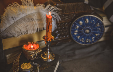 Orange candle on a vintage table, dark academia aesthetic. Evening October time
