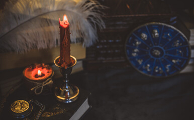 Orange candle on a vintage table, dark academia aesthetic. Evening October time