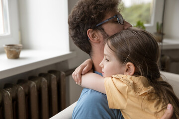 Closeup portrait loving little daughter hugging dear daddy around neck