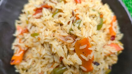 Closeup of Tasty Veg PUlav served in black dish. Vegetarian pulav with shimla mirch, onion, carrot, tomato