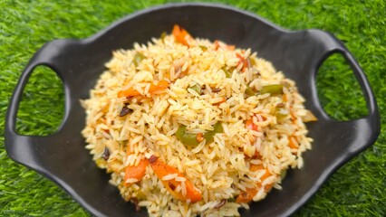 Tasty Veg PUlav served in black dish. Vegetarian pulav with shimla mirch, onion, carrot, tomato