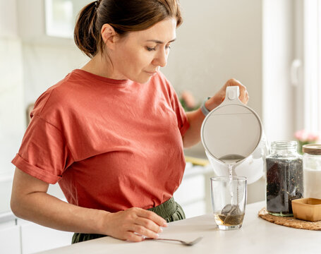 Woman Making Tea At Home In The Kitchen