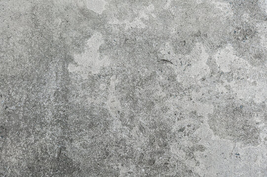 Superficie de concreto gris con textura rugosa y manchas de desgaste