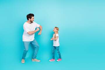 Single father and daughter enjoying a joyful moment against a vibrant turquoise background