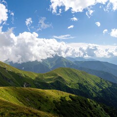 Fototapeta premium Expansive mountain vista under a vibrant sky. Lush green slopes and peaks rise into a hazy, cloud-filled blue sky. Sunlight bathes the landscape in a warm glow