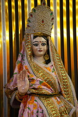 Obraz premium Traditional Indian Goddess Sita Mata Statue with Elaborate Dress and Golden Decorative Setting