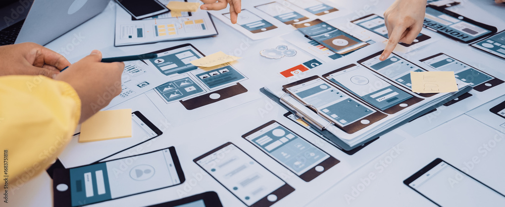 Aufkleber a vibrant workspace captures hands collaborating on a mobile app prototype. the scene features paper