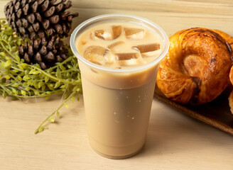 Iced Milk Tea on a Wooden Table in plastic cup side view of hong kong drink