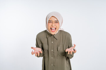 A young woman in a colorful hijab joyfully expresses herself with her hands raised high