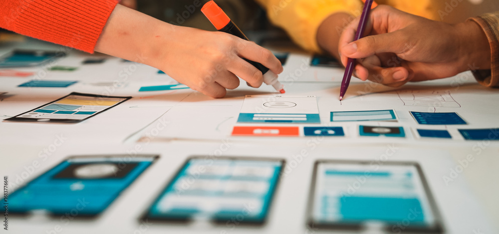 Aufkleber creative hands engaged in brainstorming during a mobile app design session, sketching interface conc