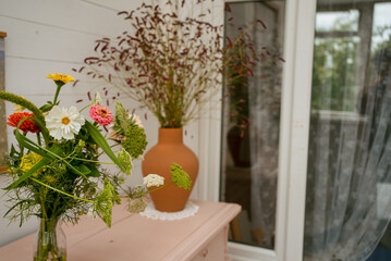 Wildflowers in glass and clay vases creating a vibrant and natural atmosphere in a cozy home interior, enhancing the aesthetic appeal of the space
