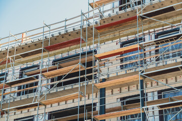Construction site with scaffolding on a building under renovation in a busy urban area during daylight
