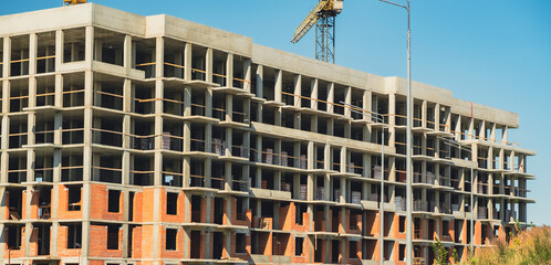 Construction site showcasing progress on a multi-story building under a clear blue sky
