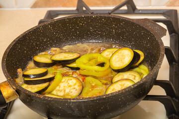 Zucchini cut into rings are fried in a frying pan in oil and spices