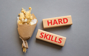Hard skills symbol. Wooden blocks with words Hard skills. Beautiful grey background with bouquet of...