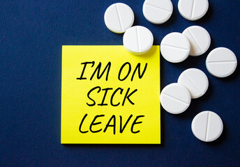 Sick leave symbol. Concept word I am on sick leave on yellow note. Beautiful deep blue background...