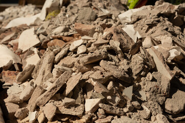 Close-up of demolition rubble with broken plaster, stone, and concrete debris.