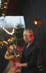 beautiful blond woman in Christmas style, girl is being prepared for the new year. walk at the street with  Christmas tree, smile, take photo