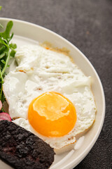 Eggs breakfast black pudding, egg, vegetables, arugula portion size natural product tasty snack...