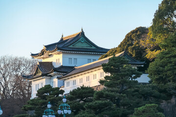 Futuristic Fuji TV Headquarters building, designed by Kenzo Tange, stands on waterfront in Odaiba, Tokyo, with its iconic sphere and lattice structure on a clear, sunny day against a bright blue sky.