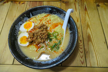 Appetizing bowl of spicy Tantanmen, a popular Japanese ramen dish, is presented with ground meat, a...
