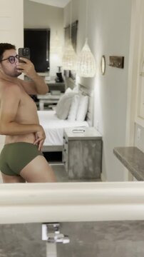 Man in swim briefs at beach house with summer atmosphere