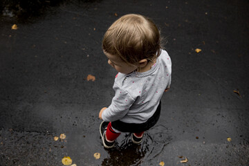 Toddler standing in puddle after rain