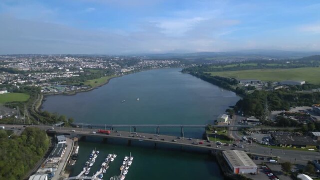Plymouth, Devon, England: DRONE VIEWS: The drone flies over the River Plym towards the Laira Bridge. Plymouth is a busy UK port and the largest operational naval base in Western Europe (Clip 1 of 5)
