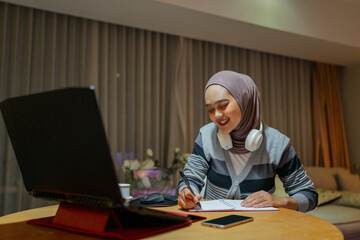 A dedicated female student is deeply engaged in her online learning experience at home