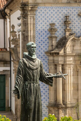 Saint sculpture ant church at background, guimaraes city, portugal