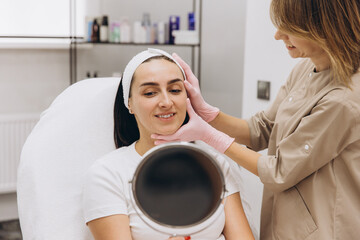 Fototapeta premium Beautician preparing woman for botox injections in cosmetology clinic